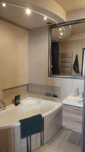 a bathroom with a large tub and a sink at MagMar Studio rynek Kluczbork in Kluczbork