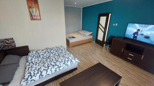 a bedroom with a bed and a tv in it at MagMar Studio rynek Kluczbork in Kluczbork