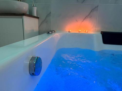 a bath tub with blue lights in a bathroom at Glamour Jacuzzi Privé Chambéry in Chambéry