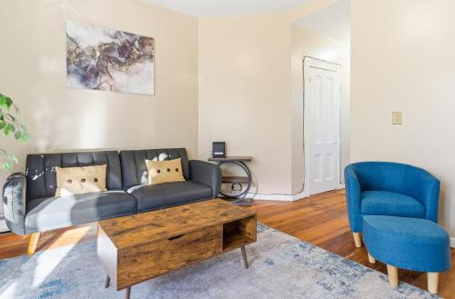 a living room with a couch and a blue chair at Chic 2BR Apartment Near Branch Brook Park in Newark