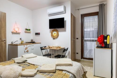 a bedroom with a bed and a kitchen with a table at L'aurora in San Vito dei Normanni