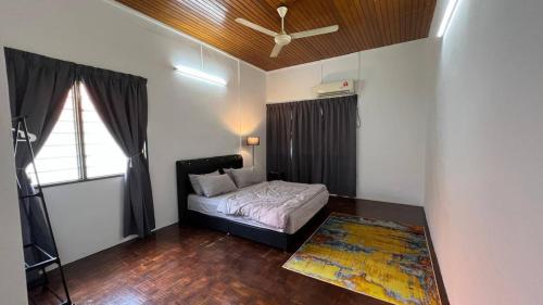 a bedroom with a bed and a ceiling fan at Bayan Lepas Getaway - Nature Views BBQ Haven in Gelugor