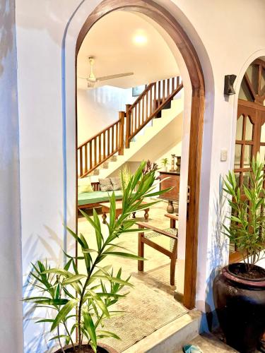 an archway leading to a staircase in a house with plants at Coastal Cloud Surf - Walk To Dewata Beach in Unawatuna