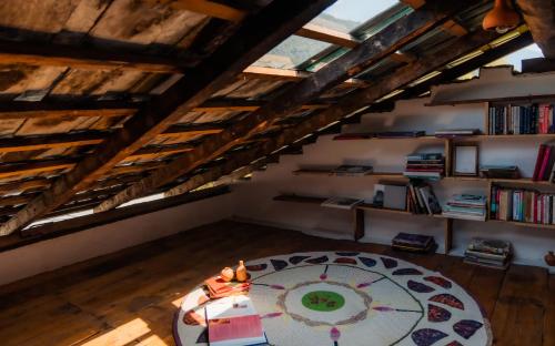 a room with a table in the middle of a attic at The Attic Library by AVVAs Stays in Bīr