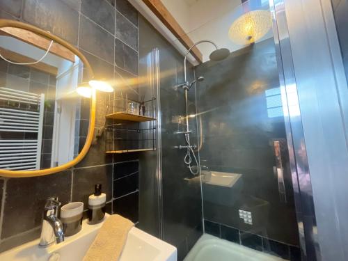 a bathroom with a shower and a sink and a mirror at Kust 1 in Egmond aan Zee