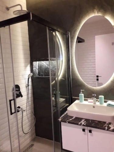 a bathroom with a sink and a shower with a mirror at C lounge cleopatra premium Apartment in Alanya