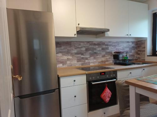a kitchen with a stainless steel refrigerator and white cabinets at Ferienwohnung Schack in Hoisdorf