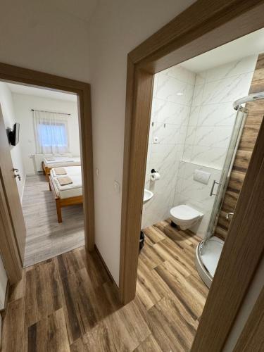 a bathroom with a shower and a toilet and a sink at Sobe Zimmer Frei in Požega