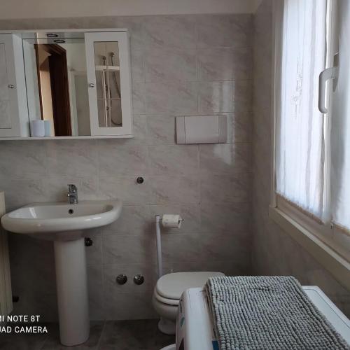 a bathroom with a sink and a toilet and a mirror at CASA VACANZE LUNA in Seriate