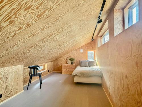 a bedroom with a bed and a chair in a room at Architect-Designed House Overlooking Valö Fjord in Hamburgsund