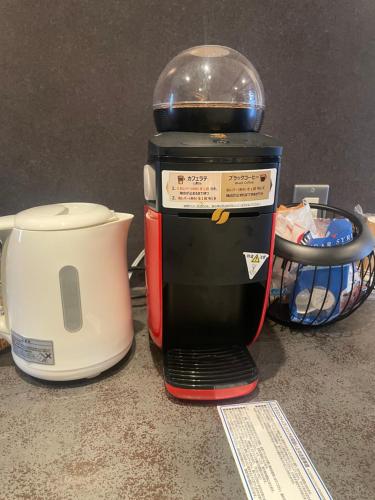 大阪SMILE HOUSE close to USJ Mario Kidsroom high class kitchen bath easy to Kobe Nara 10mins to downtown by train up to 6ppl的咖啡壶和烤面包机(位于柜台上)