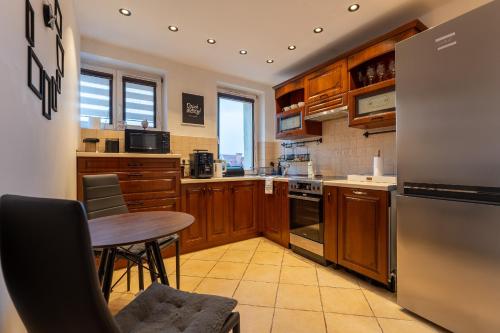 eine Küche mit Holzschränken und einem Tisch darin in der Unterkunft Ratuszove Love - dwie osobne sypialnie, w rynku - by Everslow in Jelenia Góra