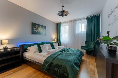 Schlafzimmer mit einem Bett, einem Schreibtisch und grünen Vorhängen in der Unterkunft Ratuszove Love - dwie osobne sypialnie, w rynku - by Everslow in Jelenia Góra