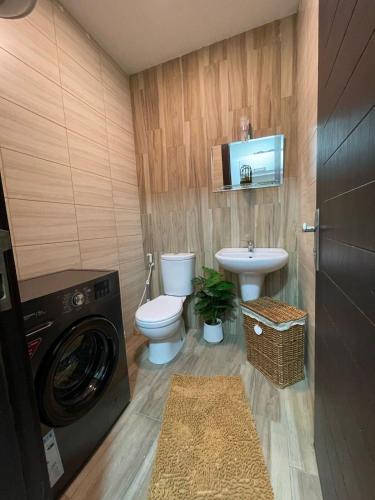 een badkamer met een wasmachine, een toilet en een wastafel bij studio with balcony in Amman