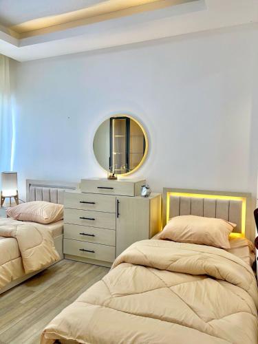 een slaapkamer met twee bedden en een spiegel aan de muur bij studio with balcony in Amman