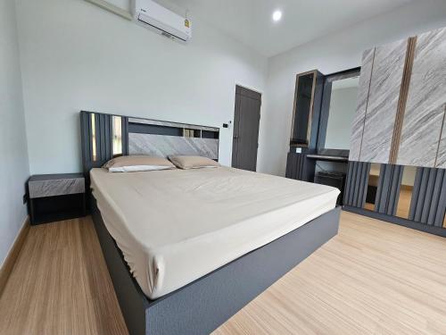 ein Schlafzimmer mit einem großen Bett in einem Zimmer in der Unterkunft Saint Sean Saraphi in Chiang Mai