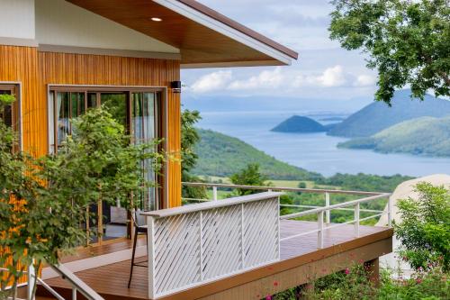 a house with a balcony with a view of a lake at Hilltop Erawan Camp in Si Sawat