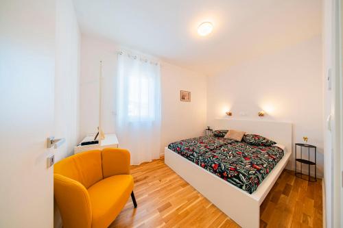 a bedroom with a bed and a chair at Flex SelfCheckIns 191 - Zagreb - 2 Bedrooms - Parking - Loggia in Zagreb