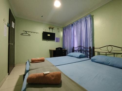 莎阿南KristaI Inn Hotel Shah Alam的卧室里有两张床和一台电视