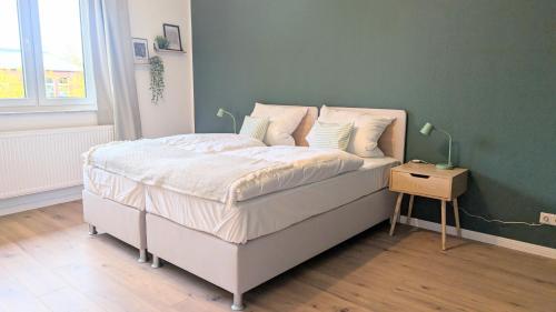 a bed with white sheets and pillows on it in a bedroom at HYGGE HOMES - Apartment 'Stilla' in Celle