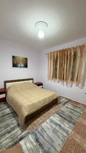 une chambre avec un grand lit dans une pièce dans l'établissement Cozy Flat, à Tirana