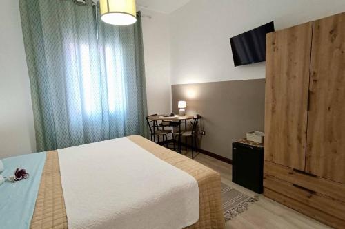 a bedroom with a bed and a table with a television at Arcu de chelu - guest house in Modolo