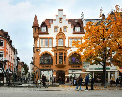 een groot gebouw met een klokkentoren in een stadsstraat bij Limehome Ravensburg Marienplatz in Ravensburg