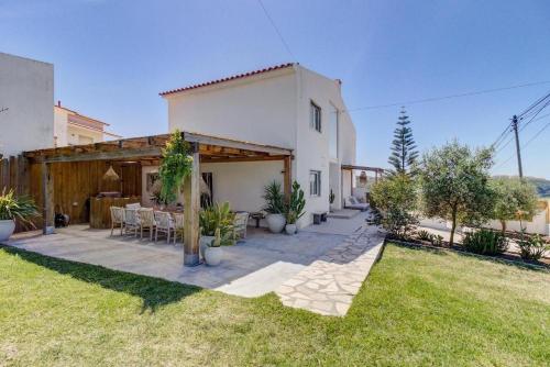 a backyard of a house with a table and chairs at Ocean House Ericeira - next to Ribeira d'ilhas Surf Beach in Ericeira
