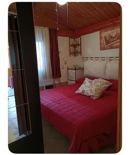 a bedroom with a red bed with two pillows on it at Lo Chalet di Loredana in Pisa