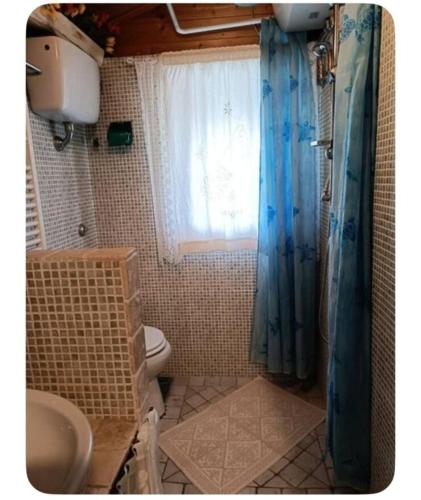a bathroom with a sink and a toilet and a window at Lo Chalet di Loredana in Pisa