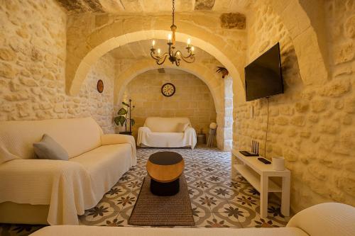 Una sala de estar con un sofá y un televisor. en Spacious Modern 3BR Oasis Villa with Private Pool, en Nadur