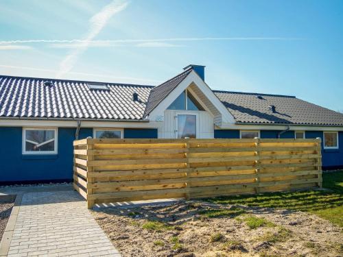 una casa con una valla de madera delante de ella en 12 person holiday home in Vestervig-By Traum, en Vestervig