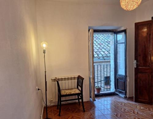 a room with a chair and a door with a window at Casa medieval Cal Moliner in Omells de Nagaya