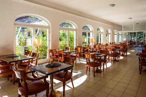 a restaurant with tables and chairs and windows at Partvilla Balatonboglar in Balatonboglár