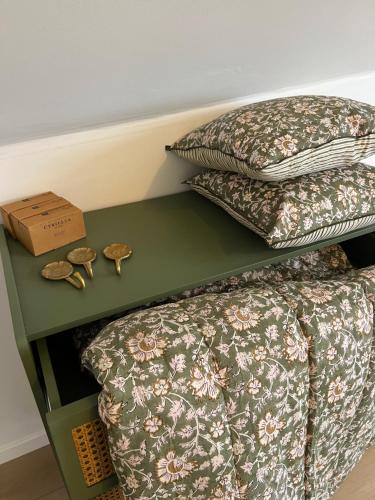 a bed with two pillows and a green table at Les Chantereines in Brugny-Vaudancourt