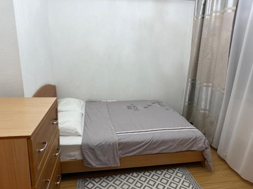ein kleines Schlafzimmer mit einem Bett und einer Kommode in der Unterkunft Enereltsogtsolbor in Ulaanbaatar