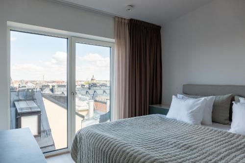 a hotel room with a bed and a large window at Grand House Stockholm in Stockholm