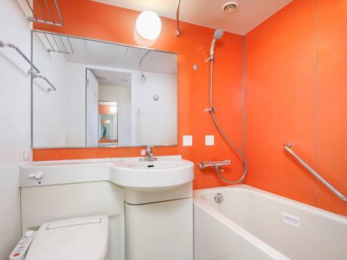 千葉市にあるコンフォートイン千葉浜野R16の洗面台、トイレ、鏡のあるバスルーム