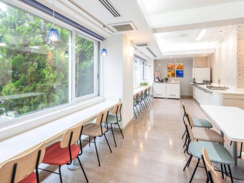 a dining room with chairs and a large window at Comfort Inn Fukui in Fukui