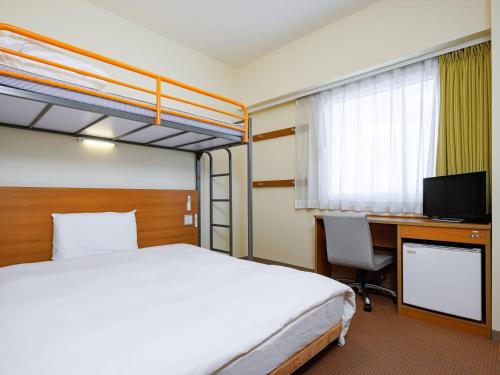 een hotelkamer met een bed en een bureau met een computer bij Comfort Inn Fukushima Nishi Inter in Fukushima