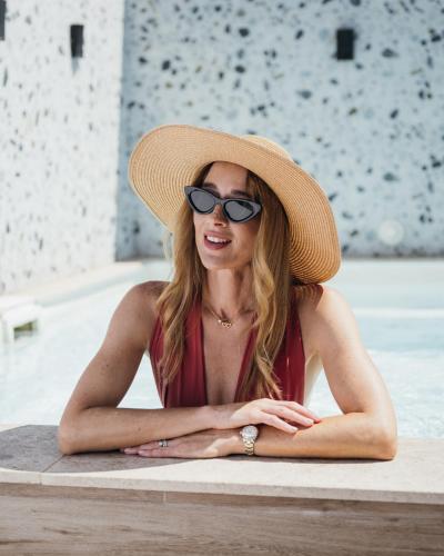 a woman wearing a straw hat and sunglasses at Strand Suites by NEU Collective in Il-Gżira