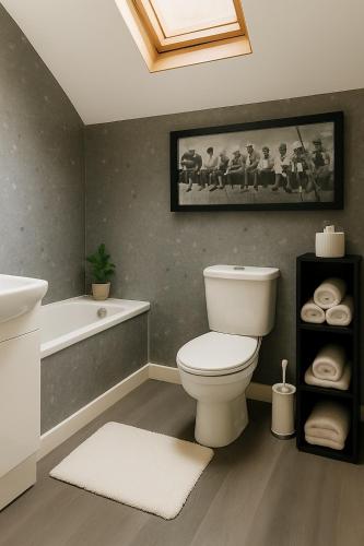 a bathroom with a white toilet and a bath tub at The Acres Retreat -Cosy and Welcoming in Lisnaskea