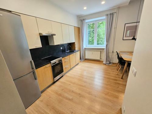 een keuken met een roestvrijstalen koelkast en een tafel bij Cosy lux Apartment with Free Parking in Tallinn