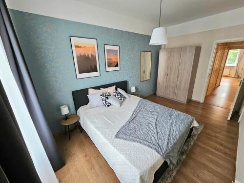 een slaapkamer met een bed en een blauwe muur bij Cosy lux Apartment with Free Parking in Tallinn