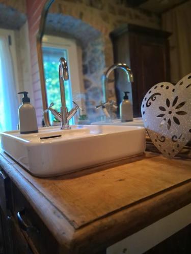 a bathroom sink with two faucets on a wooden counter at Amtawa - Bien-être et Ressourcement in Kirchberg