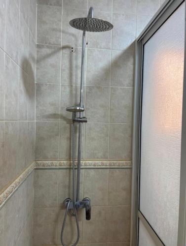 a shower with a shower head in a bathroom at Your dream home in Aouchtame