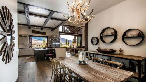 a kitchen and dining room with a wooden table and mirrors at Impressive and Secluded Villa for Rent along the Glorious Uinta Mountains, Utah in Oakley