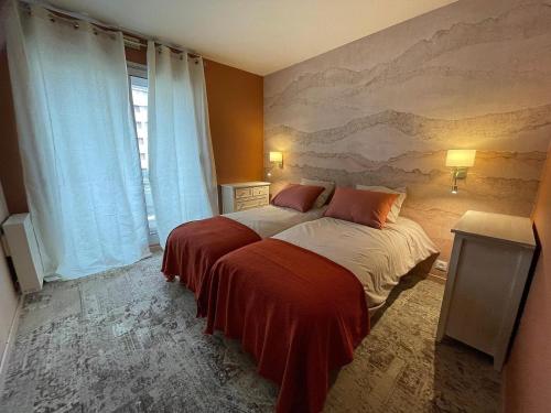 ein Schlafzimmer mit einem Bett und einem Gemälde an der Wand in der Unterkunft Casino des fleurs in Vichy