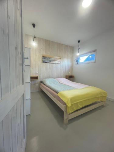 a bedroom with a bed with a yellow blanket at AgroReset CAŁOROCZNY in Korlino