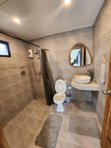 a bathroom with a toilet and a sink and a mirror at the cabin hulk เขาใหญ่ in Ban Nong Song Hong